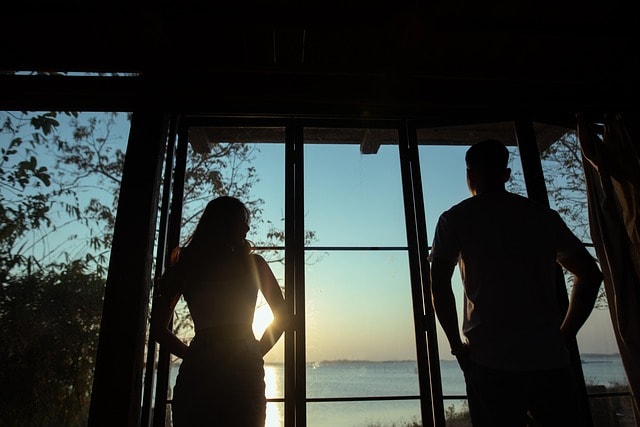 Two people staring out at a sunset